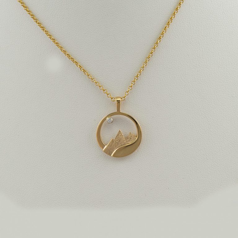 Teton flow pendant in 14kt yellow gold with a diamond accent. The diamond is a brilliant-cut, white Diamond. Chain not included.