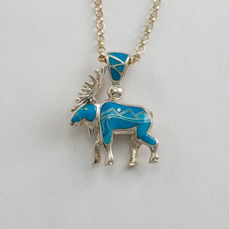 This silver moose pendant is Reversible. It features hand-done inlay on both sides. The chain is solid sterling silver and is included in the price.