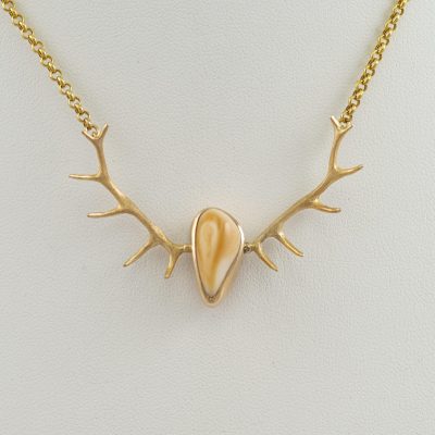 This Ivory necklace has 14kt yellow gold Antlers. This Elk Ivory was harvested from a Bull. The setting, antlers and chain are made with gold.