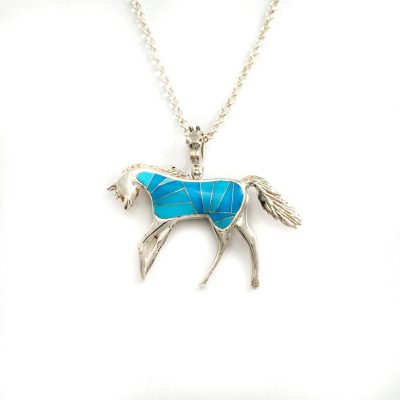 This is our reversible horse pendant. It has been cast in Sterling silver and is inlaid on both sides. The chain is silver and is included in the price.