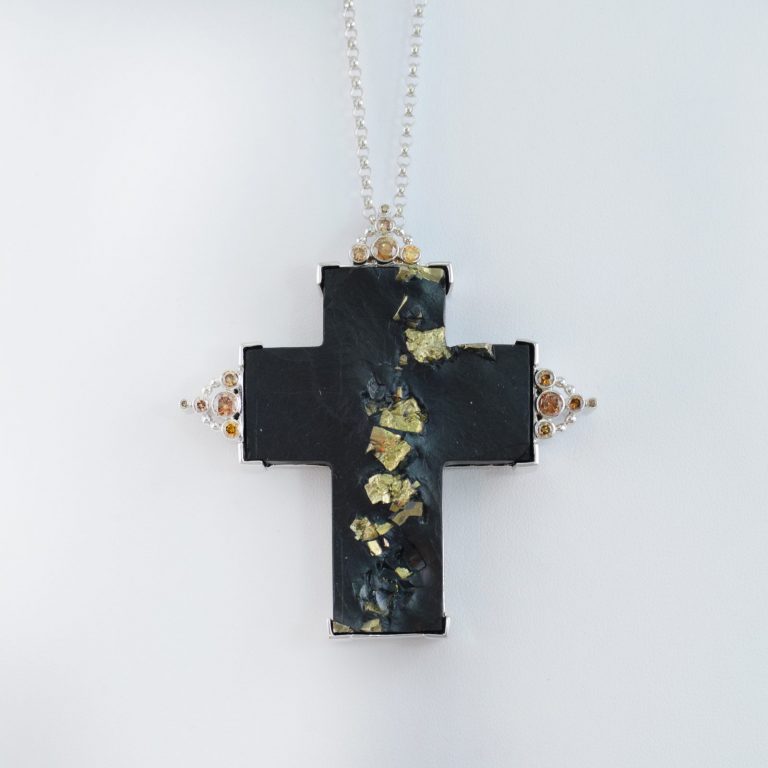 This cross pendant is made with Pyrite in Slate. Accenting the cross are Champagne Diamonds.