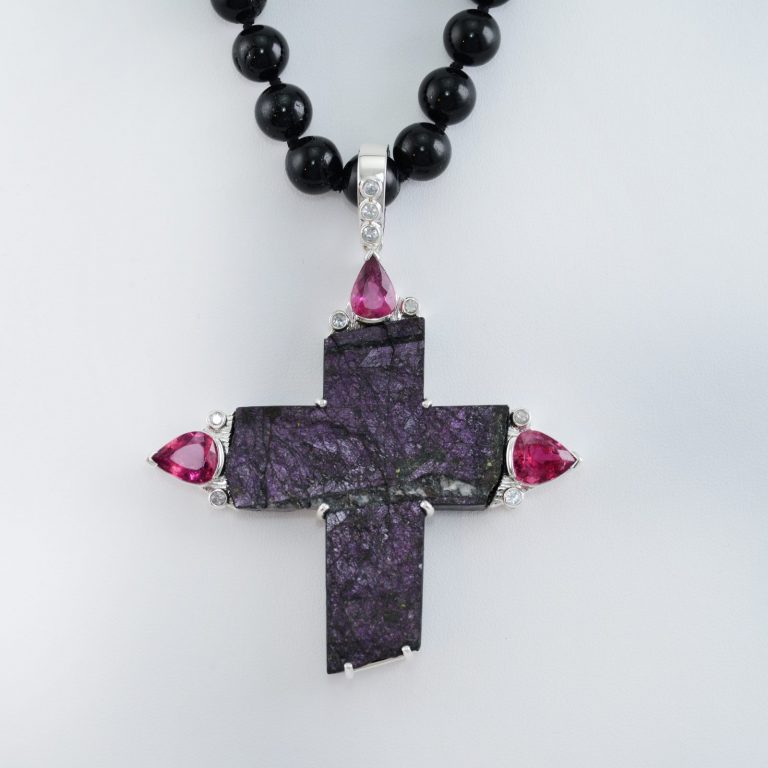 Sugilite cross with Rubelite Tourmaline and White Sapphire accents. This piece has been cast using Sterling Silver.