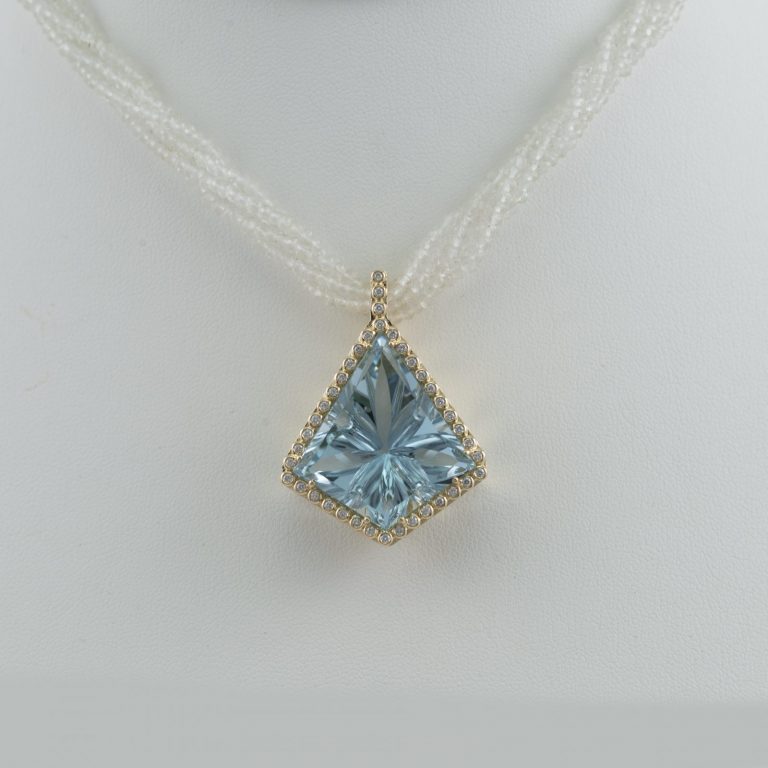 Fantasy cut blue topaz with 18kt yellow gold and white diamonds