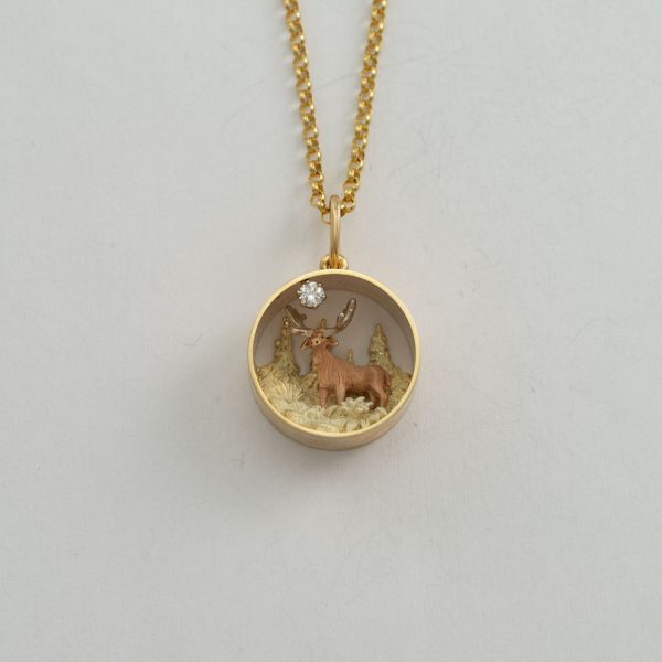 Gold moose pendant with diamond accent.