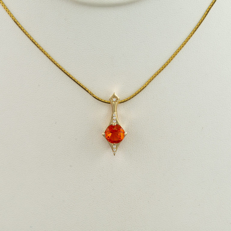 Here is a fire opal pendant. The fire opal has diamond accents. Both the opal and the diamonds have been set in 14kt yellow gold. The chain is not included in the price.