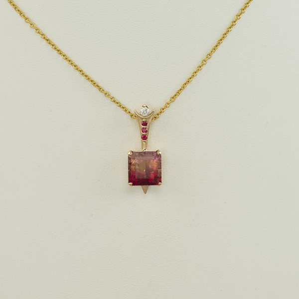 This tourmaline pendant has gold accents. Both the gold and the diamonds have been set in 14kt yellow gold. The chain is not included in the price.