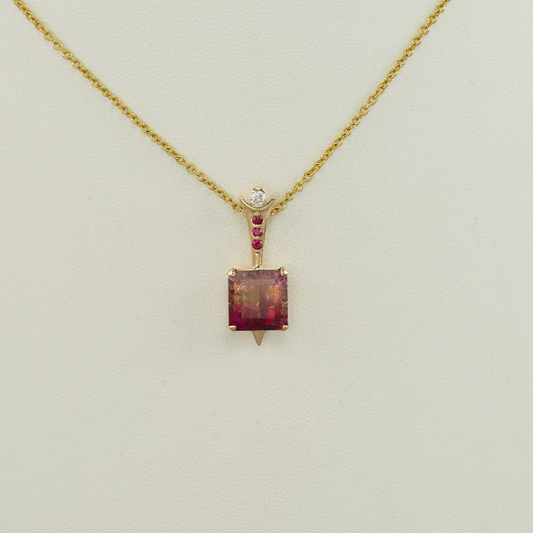 This tourmaline pendant has gold accents. Both the gold and the diamonds have been set in 14kt yellow gold. The chain is not included in the price.