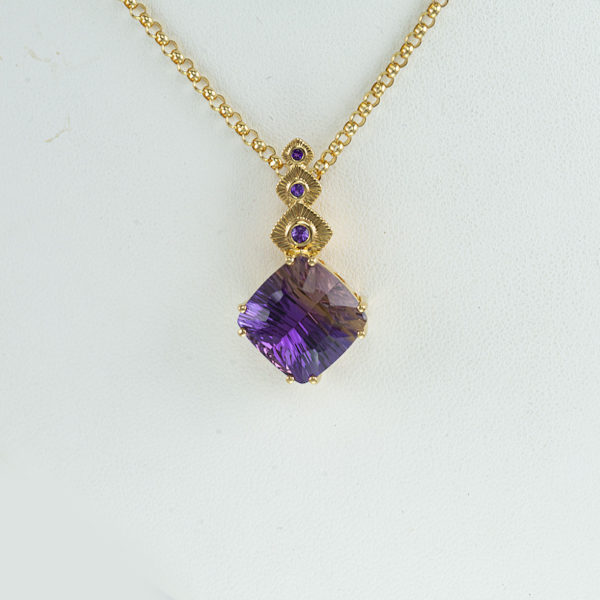 This Ametrine pendant has a center stone that is concave cut. Accenting the Ametrine are three brilliant-cut Amethyst. All of the stones have been set in Sterling Silver plated with 14kt yellow gold. The chain is not included in the price.