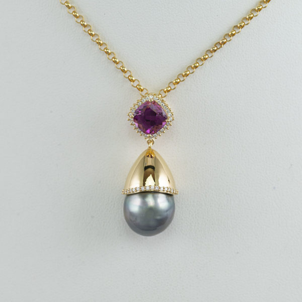Pearl pendant with mehenge garnet and brilliant cut diamonds. The pearl and all of the stones have been set in 18kt yellow gold.