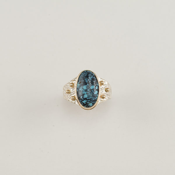 This Men's Turquoise ring has a Sterling Silver ring shank. The bezel is 14kt yellow Gold as well as several gold "BB's".