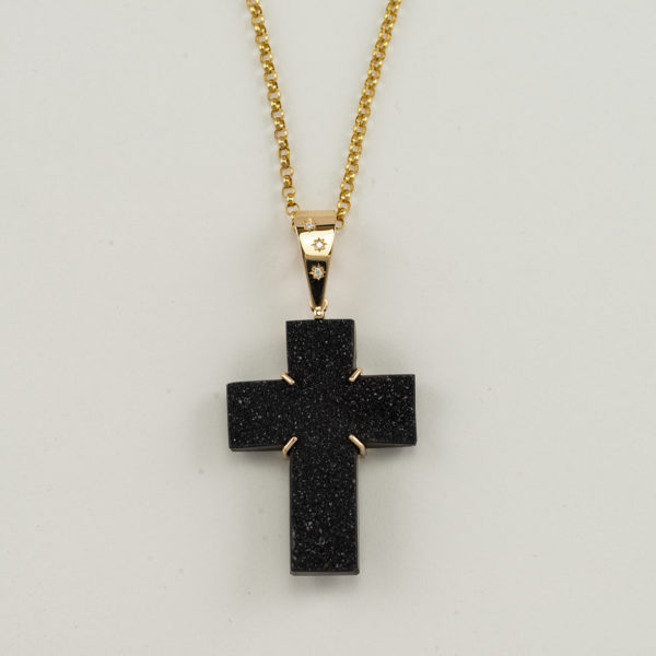 This black agate cross has diamond accents. Both the black agate and the diamonds have been set in 14kt yellow gold.