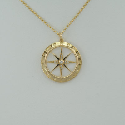 Compass pendant with gold, diamonds, and mother of pearl