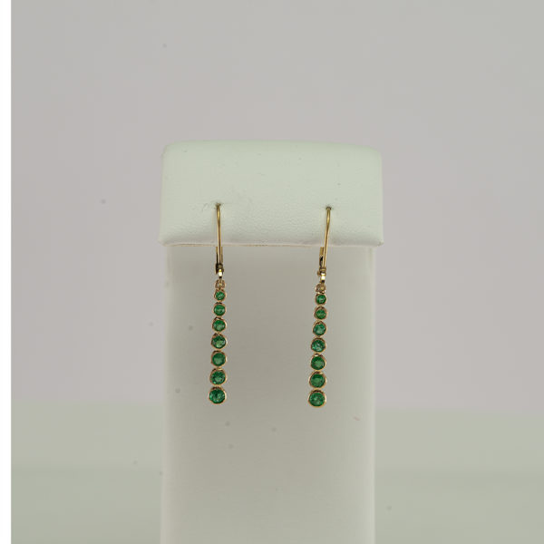 These emerald earrings have been set in 14kt yellow gold. They have been made with leverbacks and feature seven emeralds.