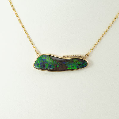 This boulder opal necklace has diamond accents. Both the opal and the champagne diamonds have been set in 14kt yellow gold. The chain is included in the price.