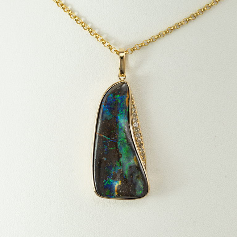 Here is a boulder opal necklace with champagne diamond accents. Both the opal and the diamonds have been set in 14kt yellow gold.