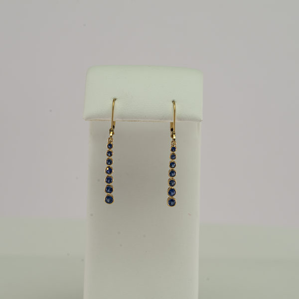These sapphire dangle earrings have been made with 14kt yellow gold. We also offer these earrings in sleeping beauty turquoise.