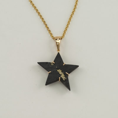 This star pendant was made with 14kt gold and diamonds. The star is slate with pyrite accents. The chain is not included.