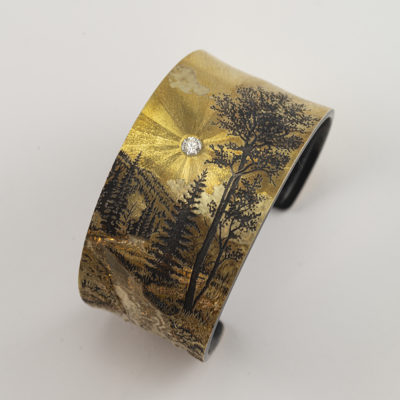This mountain cuff was created by Wolfgang Vaatz. Wolfgang has used a combination of sterling silver, 14kt and 18kt gold.