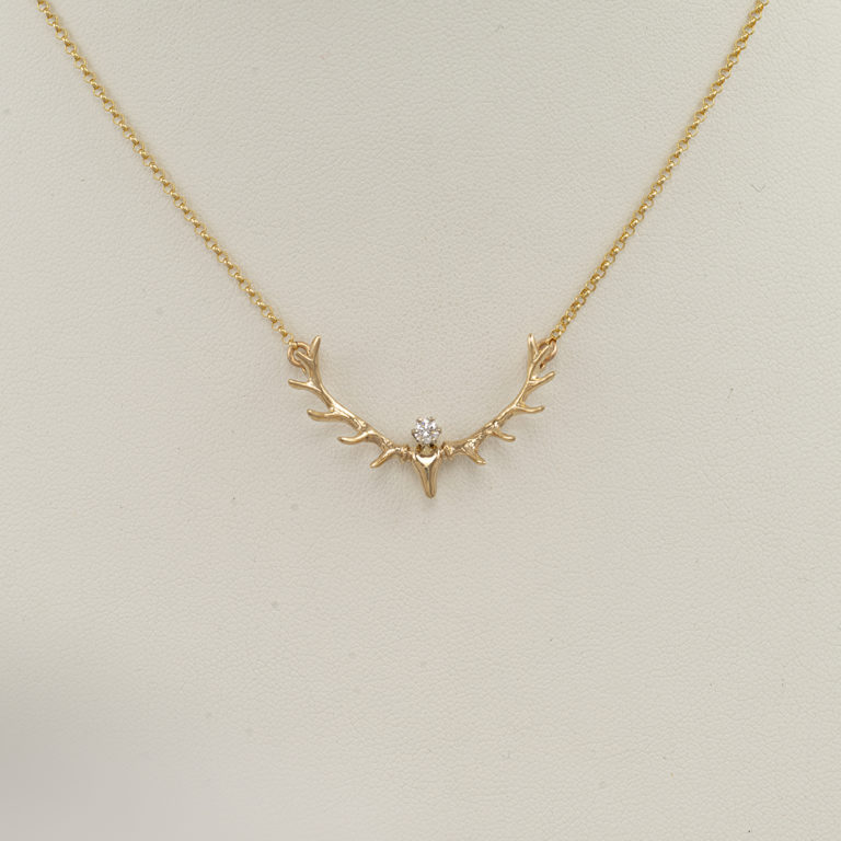 Here is an antler and diamond necklace in yellow gold. The diamond is .10ct and the gold is 14kty. The necklace has a lobster claw clasp.