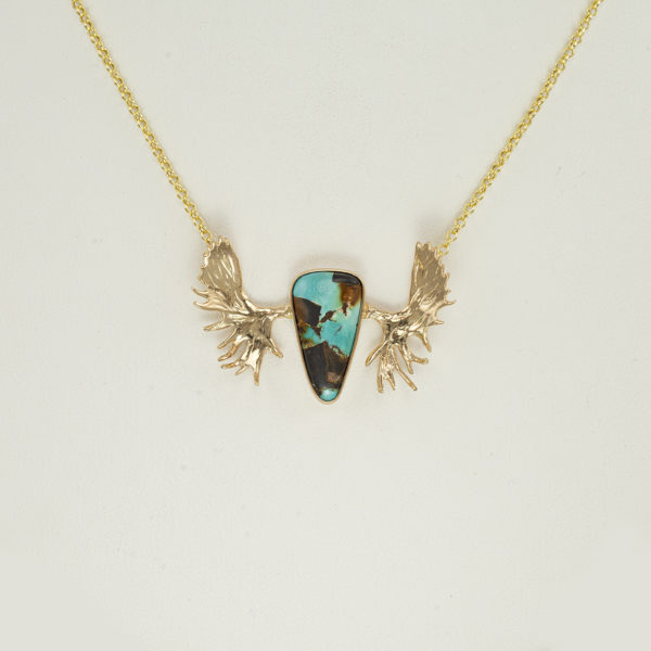 This moose necklace was made with 14kt yellow gold. This pendant features a beautiful piece of Carico Lake Turquoise. The chain is 17.5" in length. The clasp is a lobster claw.