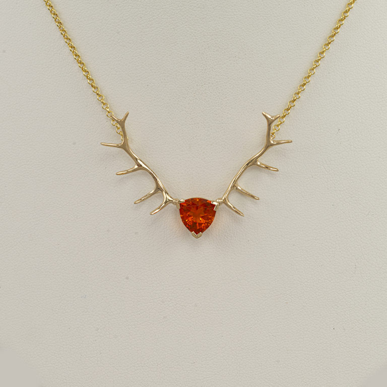 This is our opal antler necklace. The fire opal is a trillion cut and has been set in 14kt yellow gold. The chain has a nice lobster claw.