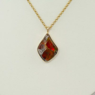 This raw fire opal has been set in 14kt yellow gold and has a sterling silver backplate. The chain is sold separately.