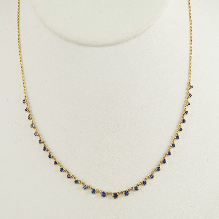 This blue sapphire necklace was made using 14kt yellow gold. The sapphires have been bezel set and have a total weight of 10.63cts. The chain can be worn at 16, 17 or 18 inches and has a lobster claw clasp.