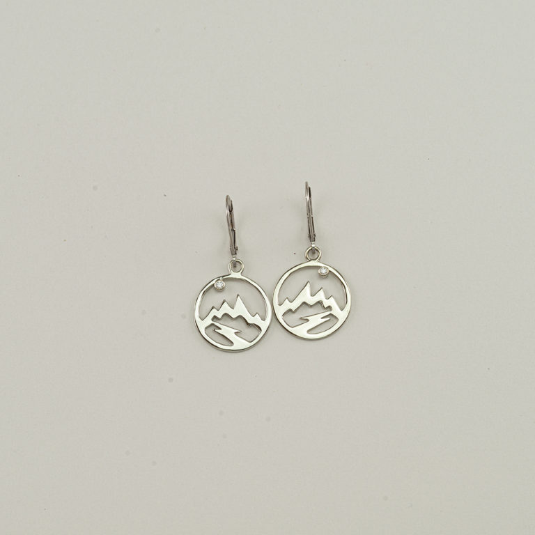 These are our round Teton earrings. They have been made in 14kt white gold. For an accent our designer has used a brilliant-cut diamonds.