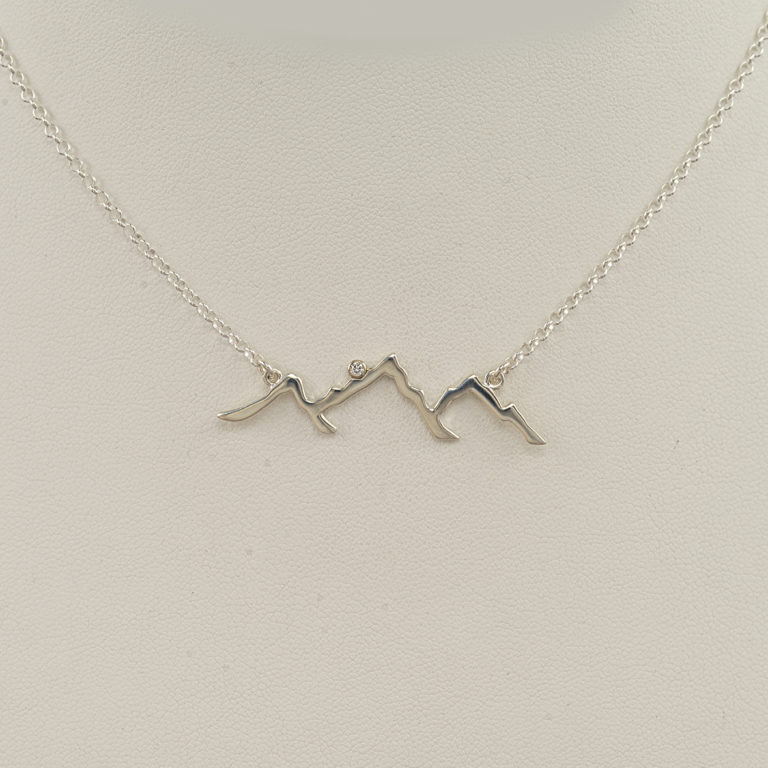 This is our Teton outline pendant. This particular piece is solid sterling silver. It has a white that has been tube set.