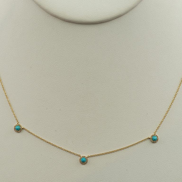 This contemporary turquoise necklace has diamond accents. Both the diamonds and turquoise have been set in 14kt yellow gold.