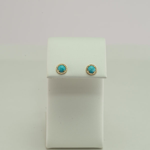 These sleeping beauty studs have diamond accents. Both the turquoise and the diamonds have been set in 14kt yellow gold.