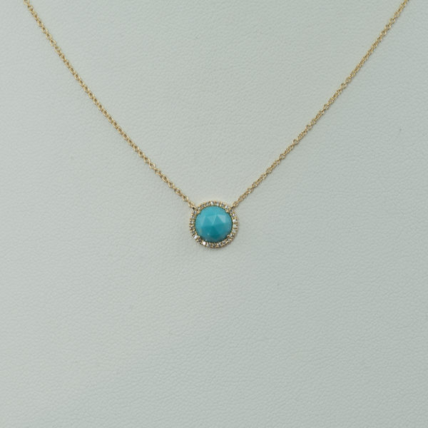 This turquoise necklace has diamond accents. The turquoise is from the sleeping beauty mine and the diamonds are white. Both the diamonds and the turquoise have been set in 14kt yellow gold. We have earrings to match and offer the pendant and earrings in a larger size as well.