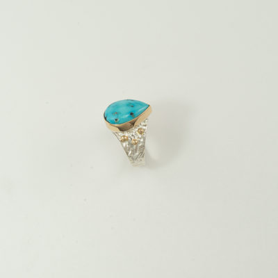 This is a turquoise and silver ring. It has gold accents. The turquoise is from the sleeping beauty mine. Shown in a size 8.25, but can be re-sized.