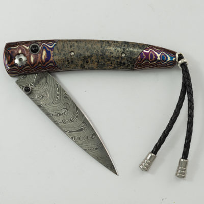 This knife is the long lost by William Henry. It is 35 of produced. It features boomerang damascus, mokume gane, black onyx and mammoth bone.