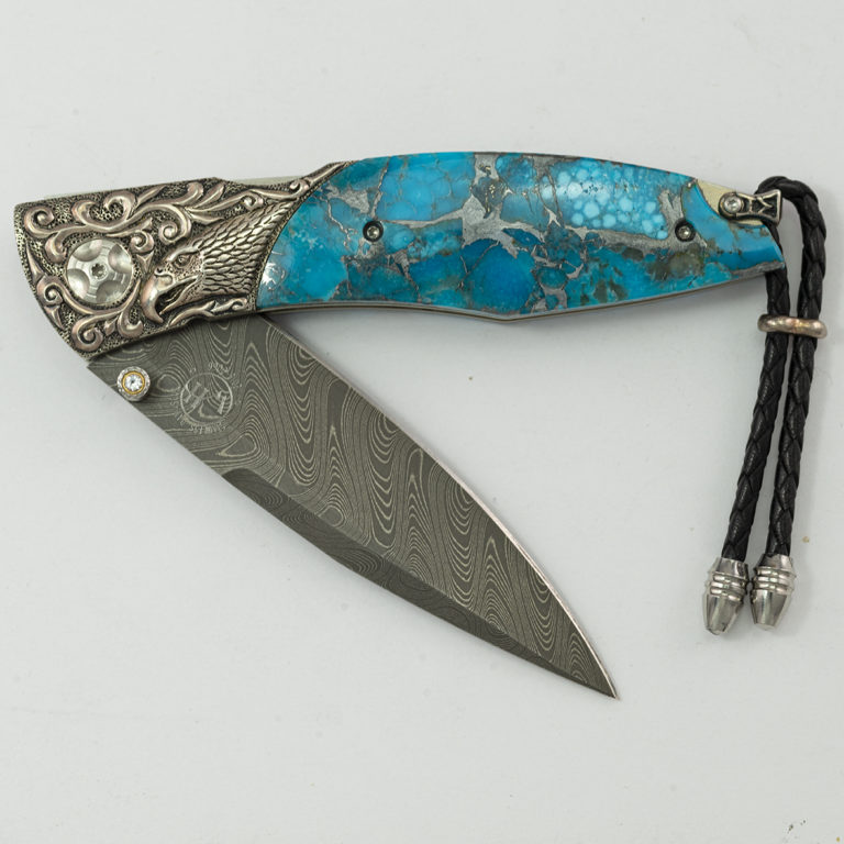 This is the Majestic by William Henry. It is 11 of 100 produced. Featuring boomerang damascus, white topaz, hand carved sterling silver and kingman turquoise with a zinc matrix.