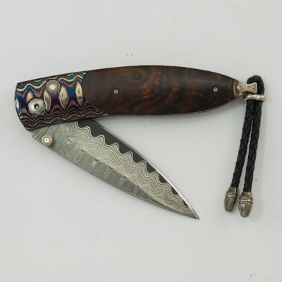 This is the Tapestry by William Henry. Number 16 of 100 produced. Featuring mokume gane, ironwood, white topaz and wave damascus. The blade is B05.