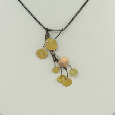 This aspen slide pendant was made by Wolfgang Vaatz. It was made with a combination of arentium silver, 14kt gold and 18kt gold. The diamond is .40cts in total weight. We also have a pair of earrings to match.