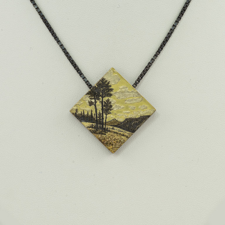 This mountain pendant was created by Wolfgang Vaatz. It was made with a combination of sterling silver, 14kt gold and 24kt placer gold.