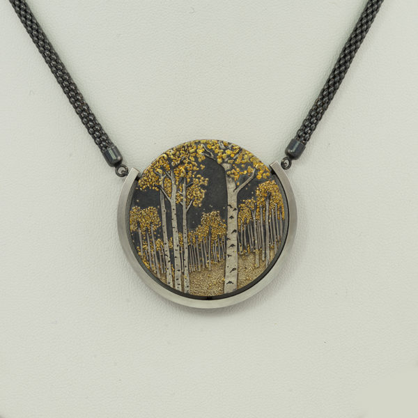 This is the aspen grove pendant by Wolfgang Vaatz. Wolfgang used a base of sterling silver and added argentium silver and 24kt placer gold to create this work of art. The chain is adjustable. 