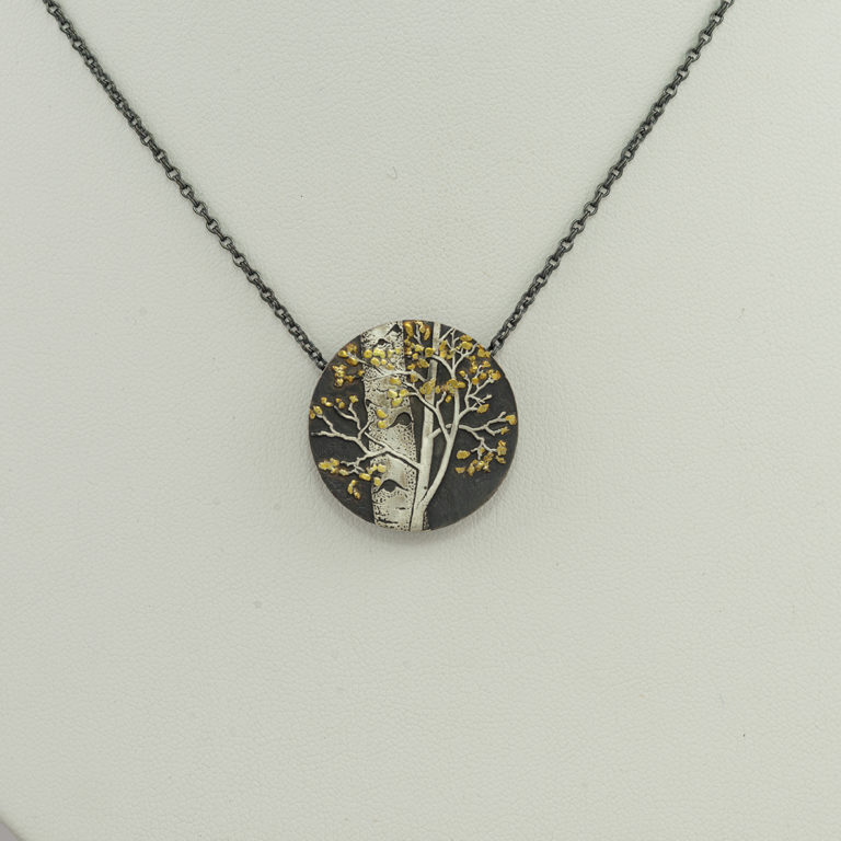 This is an aspen slide pendant by Wolfgang Vaatz. It was hand made using sterling silver, argtentium and 24kt placer gold. The chain is adjustable in length and included in the price.