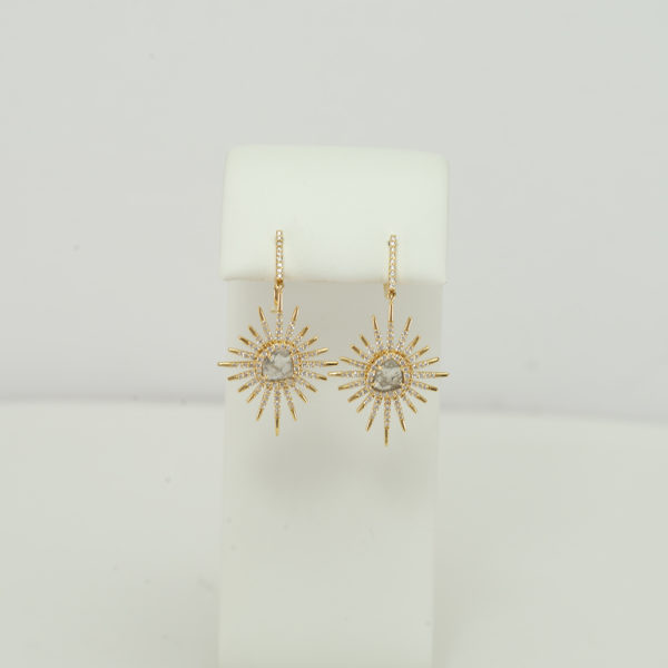 These diamond and gold earrings have been made in a starburst pattern. The gold is 18kt and the diamonds are round cut, white diamonds.
