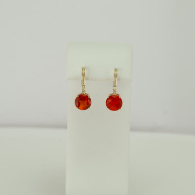 This pair of fire opal earrings has diamond accents. Both the diamond accents and the fire opal stones have been set in 14kt yellow gold.