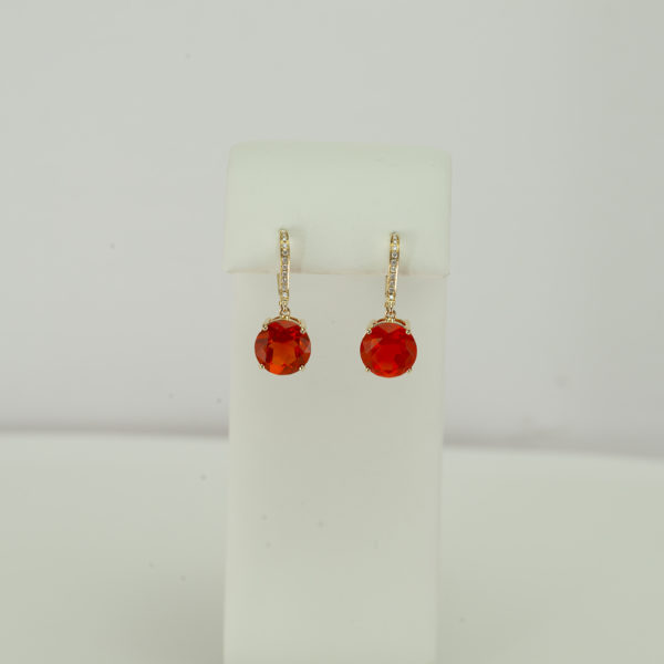 This pair of fire opal earrings has diamond accents. Both the diamond accents and the fire opal stones have been set in 14kt yellow gold.