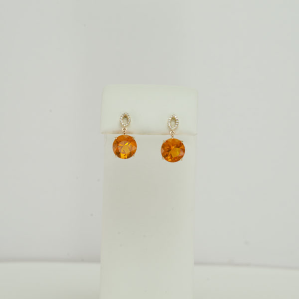 Here is a pair of fire opal earrings. They have been made with 14kt gold and have diamond accents. We also have a pendant to match.