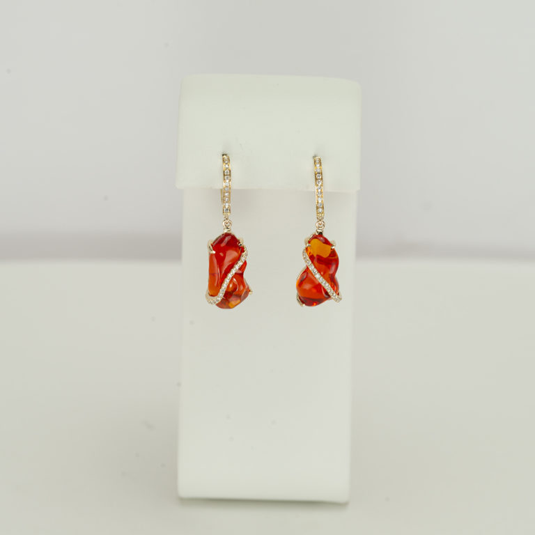 Here is a pair of fire opal earrings. The fire opal has been accented with diamonds. Both the diamonds and the fire opal have been set in 14kt yellow gold. Made with 14kt gold leverbacks. We also offer a pendant to match.