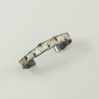 This is a silver aspen cuff by Wolfgang Vaatz. The cuff was hand made using argentium silver. Shown in a size large.