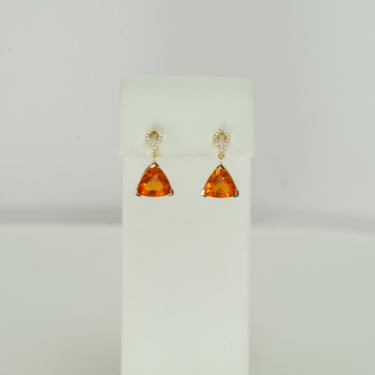 These Fire Opal Trillion Cut Dangles with Diamond Accents are set in 14KT yellow gold. The posts are also in 14KT yellow gold.