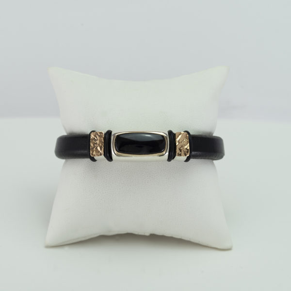 This Wyoming black jade bracelet was hand-made. It has sterling silver and 14kt yellow gold accents. The leather is cowhide and the clasp is stainless steel. It is a size 7.5".