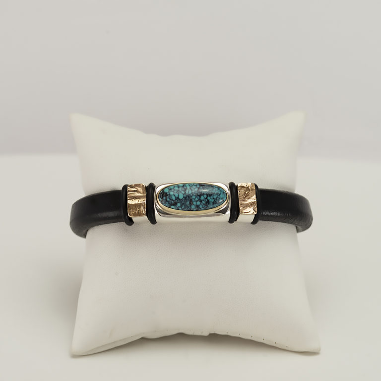 Here is a turquoise leather bracelet. It has been made with cowhide, silver, gold and a stainless steel clasp. It is a size 8.5.