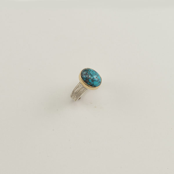 Here is a ladies turquoise and silver ring. The turquoise has been bezel set in 14kt yellow gold. The ring shank was cast in sterling silver. Shown in a size 7.25, but can be re-sized.